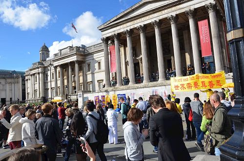 '图7-9：二零一六年十月一日下午，法轮功学员在特拉法加（Trafalgar Sqare）北平台举行集体炼功和讲真相活动，吸引众人目光。'