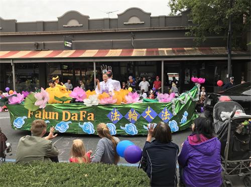 图3～4：用莲花和祥云装饰的花船上，学员们演示法轮功打坐的功法。