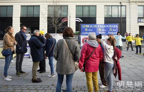 '图3：二零二一年十一月十四日，在巴黎新桥地铁站的信息日活动期间，人们驻足观看，了解法轮功真相。'