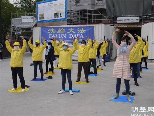 '图1：五月二十三日，法轮功学员在红山圣皮埃尔（ Saint-Pierre de Montrouge）教堂前向行人展示法轮功功法，介绍法轮功。'